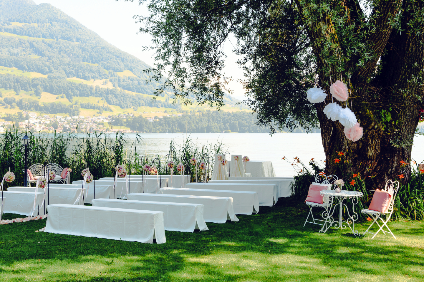 Schloss-Park mit Zeremoniebänken und Hochzeitsdekoration in Pastellfarben im Swiss-Chalet Merlischachen